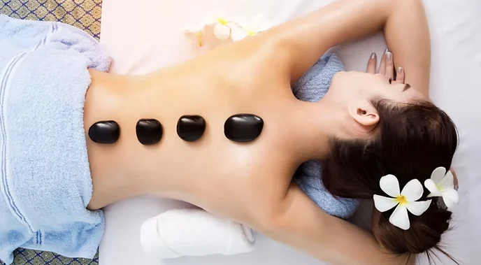Hot-Stone-Massage mit warmen Steinen am Rücken